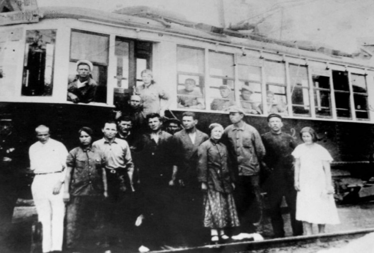 Группа рабочих и водителей у вагона, совершившего первый рейс по маршруту "Город — порт Мариуполь". 1934 год.