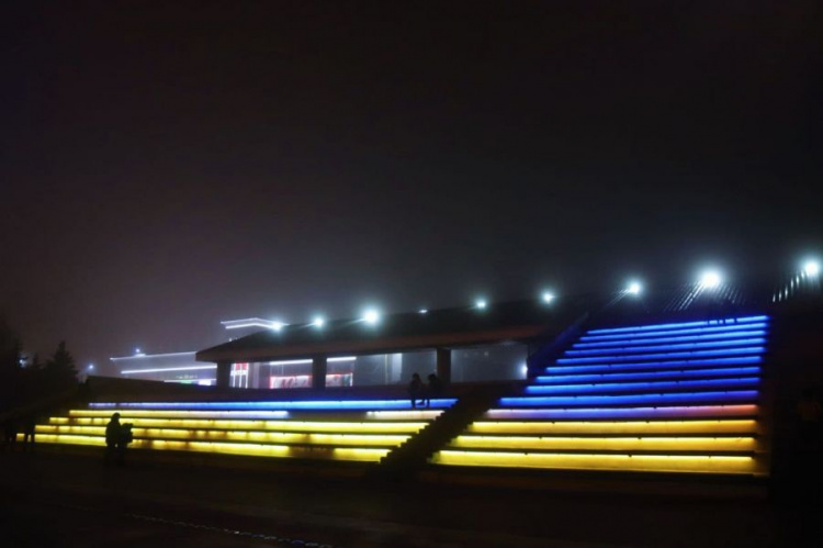 Вечернюю мариупольскую площадь освещают сине-желтые цвета