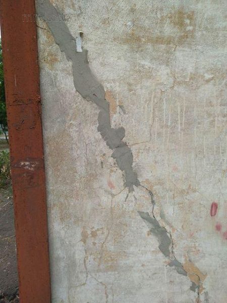 В Мариуполе рушится трехэтажка – упавшую стяжку распиливают бомжи (ФОТО)