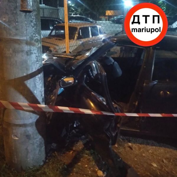 Автомобиль врезался в столб, снес будку и забор автостоянки в Мариуполе
