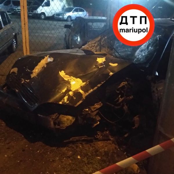 Автомобиль врезался в столб, снес будку и забор автостоянки в Мариуполе