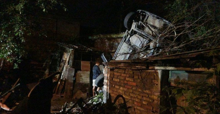 В Мариуполе автомобиль снёс два забора и оказался на крыше дома (ФОТО)